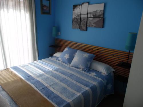 1 dormitorio azul con 1 cama con pared azul en Hostal La Lluna, en Arenys de Mar