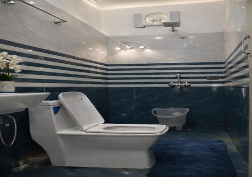 a bathroom with a toilet and a sink at Hotel MountMemory , Barkot-Yamunotri in Barkot