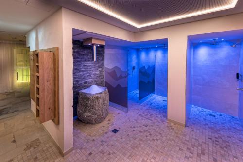 a bathroom with a shower with purple lighting at Hotel Jennys Schlössl in Serfaus