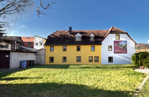 a yellow and white house with a yard at hausamsolschacht in Bad Kösen