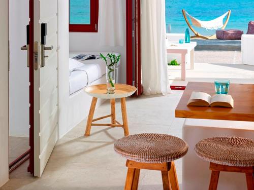 a room with a table and two stools in front of a door at Unique Milos Suites in Pollonia