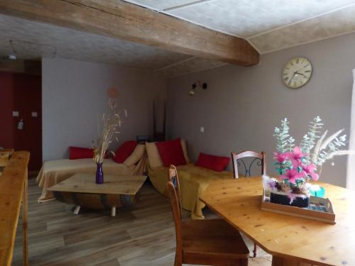 a living room with a couch and a table at Chambre hibiscus in La Roche-sur-Yon