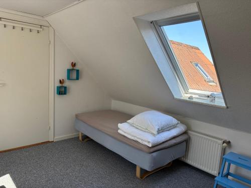 a small room with a bed and a window at Tante Jannis Sommerpension in Bogense