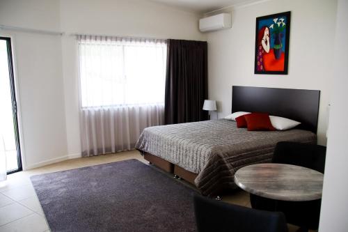 a bedroom with a bed and a table and a window at Boonah Valley Motel in Boonah