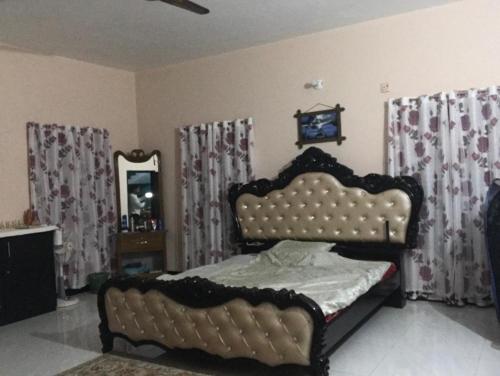 a bedroom with a bed and a mirror and curtains at Lucky villa in Sylhet