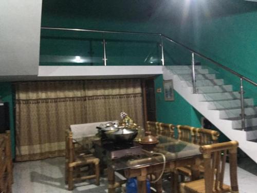 a dining room with a table and a staircase at Lucky villa in Sylhet
