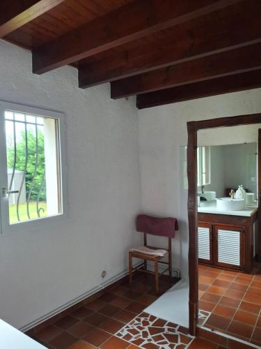 a room with a mirror and a chair and a sink at Maison familiale Pays Basque in Ahaxe-Alciette-Bascassan