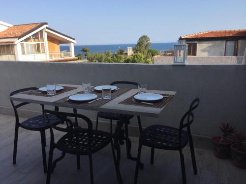 une table et des chaises assises sur un balcon avec une table et des chaises dans l'établissement La casa di Teseo, à Cannizzaro