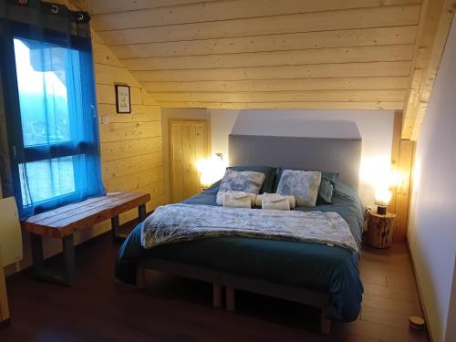 a bedroom with a bed with two pillows on it at Le Chalet de l'Ancerf in Faucompierre