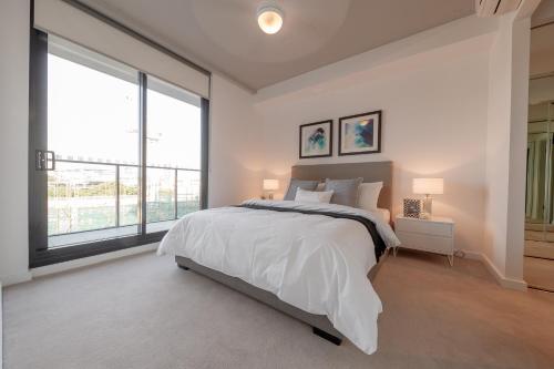 a bedroom with a large bed and a large window at King Street Residences in Brisbane