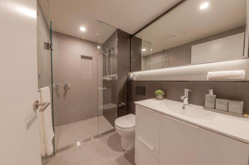a bathroom with a toilet and a sink and a shower at King Street Residences in Brisbane