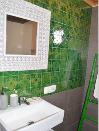 a green tiled bathroom with a sink and a mirror at Casa do Porto da Horta in Horta