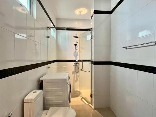 a white bathroom with a shower and a toilet at Grand Kamala Falls in Kamala Beach