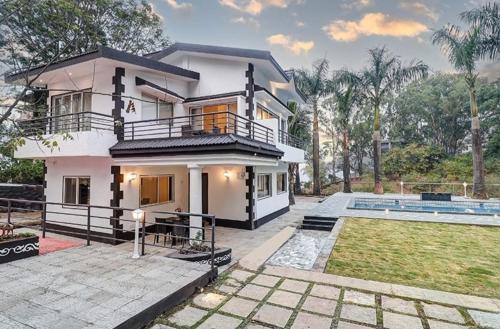 a house with a swimming pool in front of it at Esperanza Villas by SVAR Stays in Panchgani