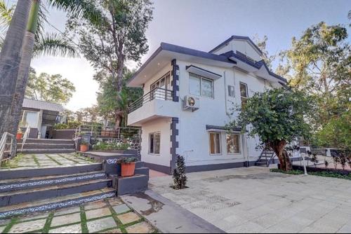 a white house with a tree in front of it at Esperanza Villas by SVAR Stays in Panchgani