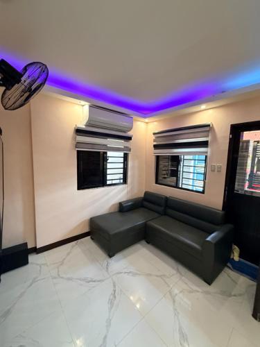 a living room with a black couch and purple lights at serene genar in General Trias