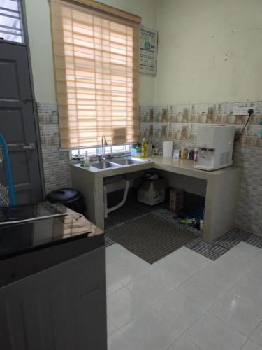 a kitchen with a sink and a counter top at Dsurau Homestay in Kota Bharu