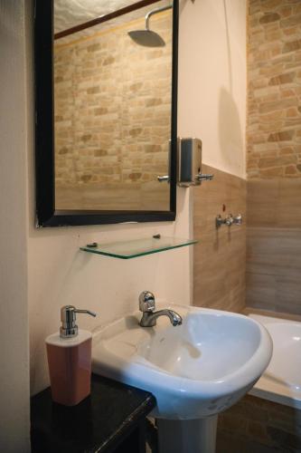 a bathroom with a sink and a mirror and a tub at Carpao Lodging Galapagos in Puerto Ayora