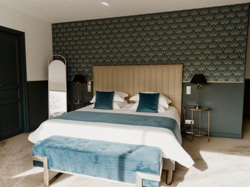 a large bedroom with a large bed with blue pillows at Domaine de Thironne Lac & Nature in Montigny-le-Chartif