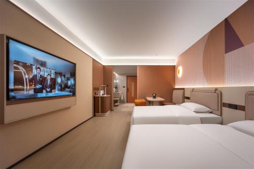 a hotel room with two beds and a flat screen tv at Dorsett Wuhan in Wuhan