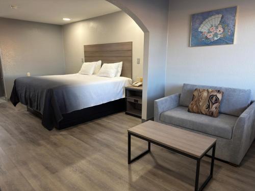 a hotel room with a bed and a chair at Americas Best Value Inn Cabot in Cabot