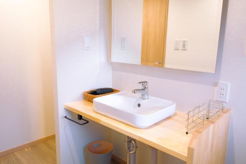 a bathroom with a white sink and a mirror at rinne 北軽井沢 Forest2 in Tsumagoi
