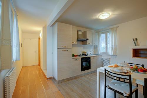 a kitchen with a table and a dining room at Torbole Lake Front - Happy Rentals in Arco
