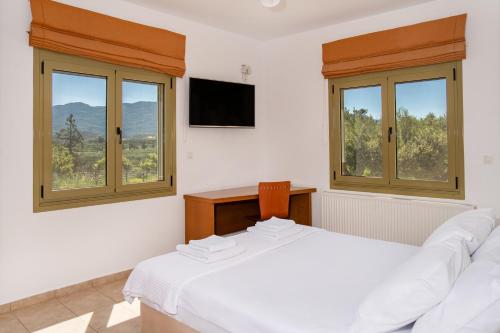 a bedroom with a bed and two windows at Panorama Villa Sitia in Sitia