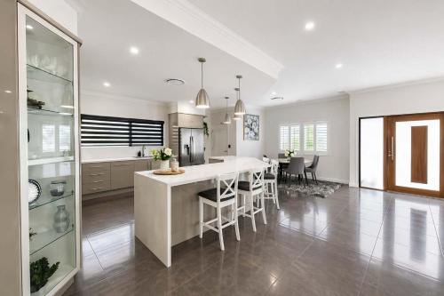a kitchen with a table and chairs in a room at Magic on MacArthur - Modern 4BR Home in Annandale in Rosslea