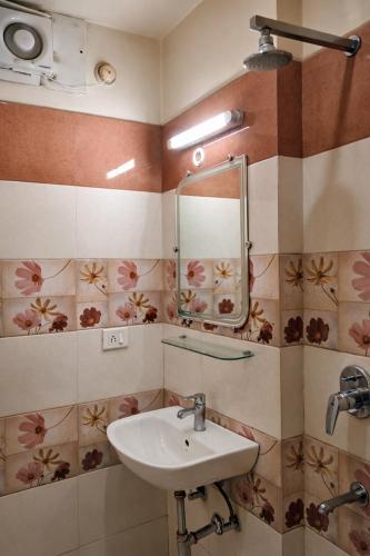 a bathroom with a sink and a mirror at Hotel Benaras Gharana Inn in Varanasi