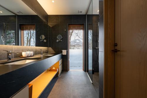 a large bathroom with two sinks and a doorway at Kogetsu To 湖月燈 in Lake Toya