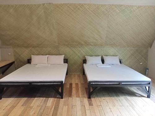 two beds sitting next to each other in a room at Campo De Laiya in San Juan