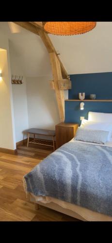 a bedroom with a bed with a blue wall at La Villa de Paul - Les Chambres in Yenne