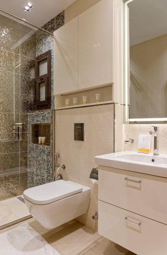 a bathroom with a toilet and a sink and a shower at La Mirada New Cairo in Cairo