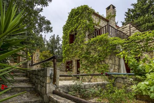 an old stone house with ivy growing on it at Manoli's House in Douliana