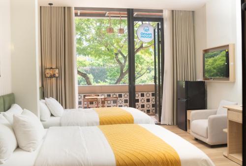 a hotel room with two beds and a window at OnsenHouse Boutique Stay - Căn hộ gần biển Mỹ Khê in Danang