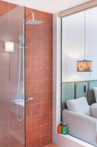 a shower in a bathroom with orange tiles at OnsenHouse Boutique Stay - Căn hộ gần biển Mỹ Khê in Danang