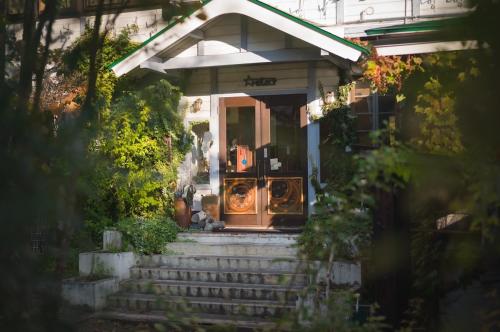 a home with stairs leading to the front door at Hakuba Pension & Log Hotel Meteor in Hakuba