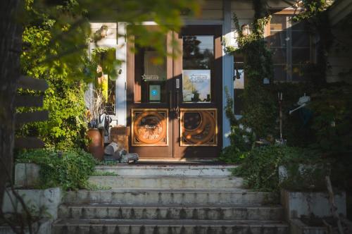 an open front door of a house with stairs at Hakuba Pension & Log Hotel Meteor in Hakuba