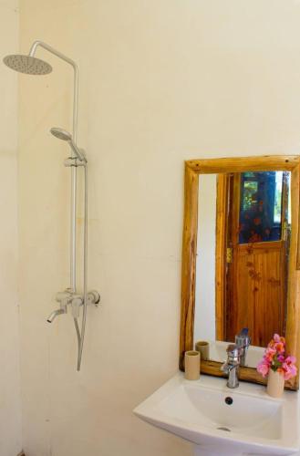 a bathroom with a sink and a mirror at Mbao Boutique Bungalows in Jambiani