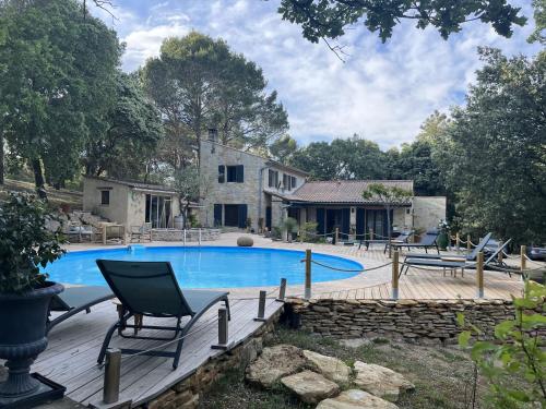 a swimming pool with chairs and a house at Maison Terre de Lune in Mondragon