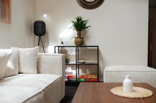 a living room with a white couch and a table at Hang The Hat House in Valmiera