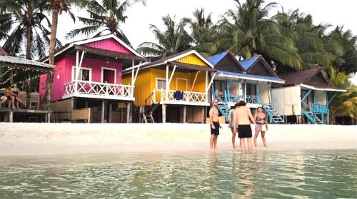 a group of people standing in the water on a beach at Paradiso Ocean front Bungalows in Koh Rong Island