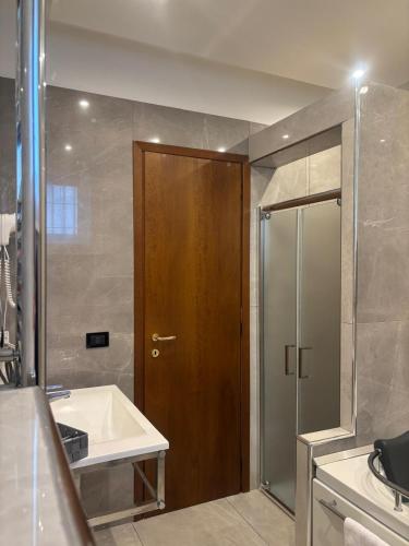 a bathroom with a shower and a sink and a wooden door at Il Castello in Terzigno