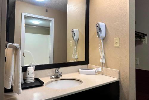 a bathroom with a sink with a phone and a mirror at Super 8 by Wyndham Booneville in Booneville