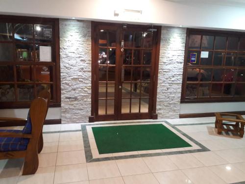 a lobby with a green mat in front of doors at Hotel Teomar in Villa Gesell