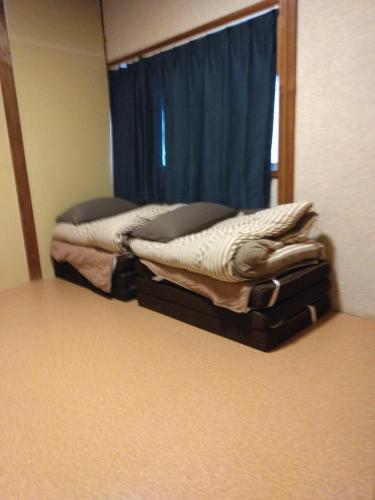 a room with two beds in front of a mirror at OKAYAMA Backpackers in Okayama