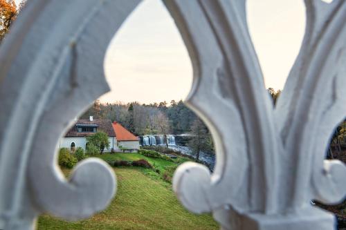 a view of a house from a metal fence at Schloss Fall, Keila-Joa in Keila-Joa