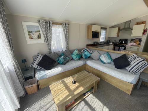 a living room with a couch and a table at Golden Dunes Retreat, Dog-Friendly Stay at Par Sands Holiday Park, Cornwall in Par
