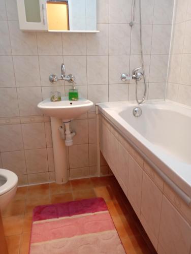 a bathroom with a sink and a tub and a toilet at ADELA Apartment center city in Ruse